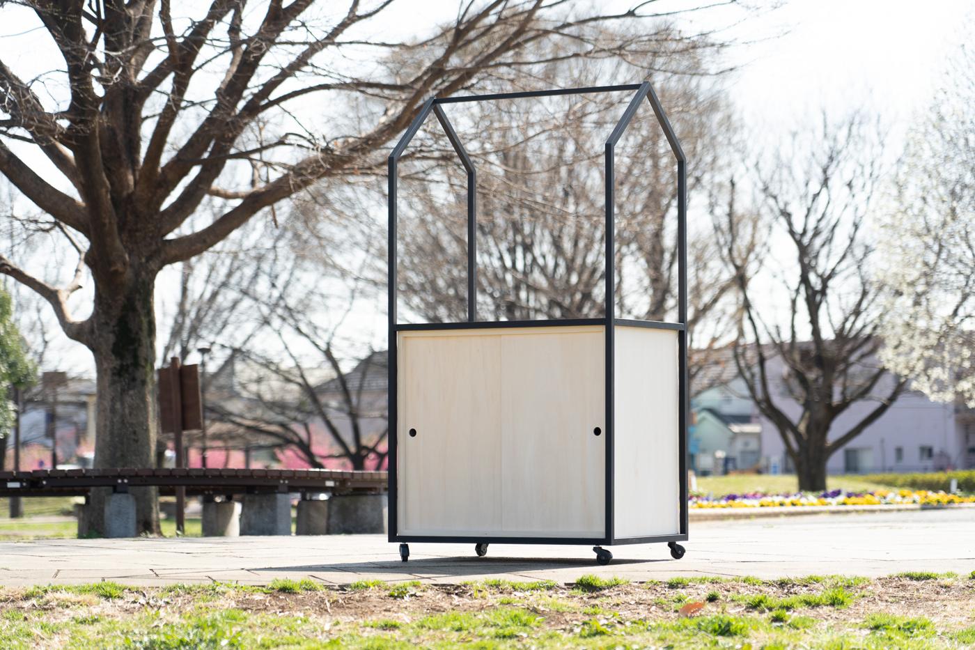 公園に置かれた家型フレームの移動カート